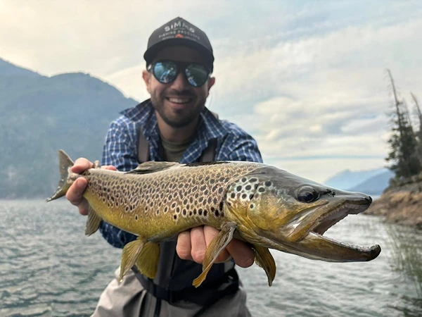 Pescador mostrando una trucha marrón