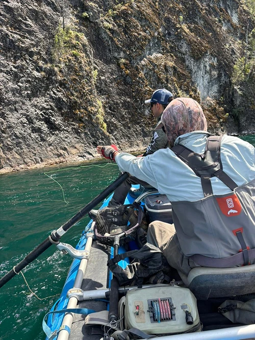 Pescadores en balsa junto a un paredón