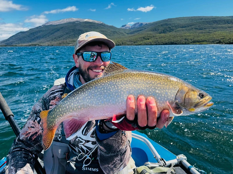 Pescador con fontinalis embarcado en un lago patagónico