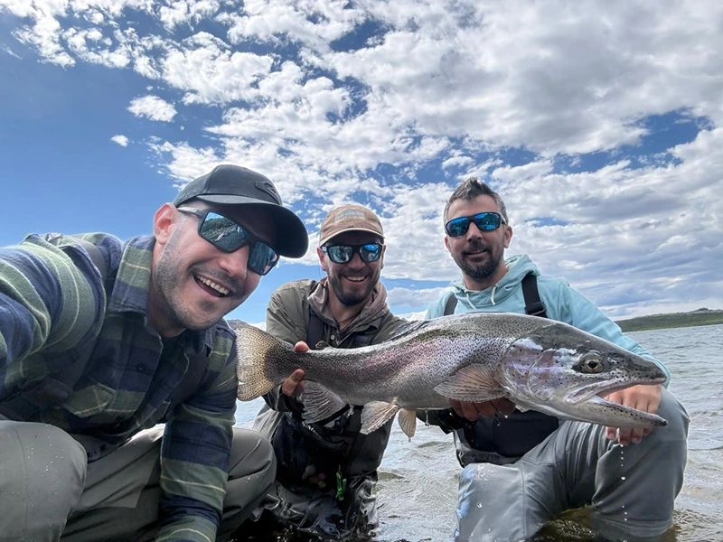Pescadores con una trucha arcoíris en Patagonia